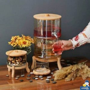 کلمن پذیرایی شیشه ای دو طبقه درب و پایه چوبی شامپاینی آرکو برای نوشیدنی با ظرفیت بالا – ظرف شیشه ای کریستالی زیبا به شما امکان نمایش و سرو نوشیدنی های سرد را برای موارد مختلف می دهد. ظرفیت 4+4 لیتری برای دسته های بزرگ لیموناد، چای سرد، پانچ، نوشیدنی های مخلوط و …. کافی است یک لیوان را زیر لوله اکریلیک ضد نشتی کلمن شیشه ای دو طبقه شامپاینی قرار دهید، آن را با نوشیدنی مورد علاقه خود پر کنید و به سبک زیبای کانتری دستگاه پخش کننده نگاه کنید. شامل شیر کرومی و بدنه شیشه ای کریستالی ضخیم است که زیر نور خورشید می درخشد. درب محفظه هوا را بردارید، به راحتی مواد خود را داخل آن بریزید و در عرض چند ثانیه یک مرکز عملی (و زیبا!) ایجاد کنید. ساخت و ساز بادوام و طولانی مدت کلمن پذیرایی شیشه ای دو طبقه آرکو شیشه ضخیم و بادوام. درب شیشه ای و لوله بدون چکه در موقعیت بهینه برای ریختن روی میز یا پیشخوان. قبل از استفاده، شیر کلمن را با هر دو واشر جانبی سفت کنید. سهولت تمیز کردن سریع و آسان کلمن پذیرایی شیشه ای دو طبقه درب بالا به راحتی برای پر کردن و پر کردن مجدد با یخ، مایعات، لیمو خرد شده، نعناع و سایر مواد در طول مهمانی برداشته می شود. وقتی برای تمیز کردن آماده هستید، به سادگی با دست بشویید، بگذارید خشک شود و برای دفعه بعد ذخیره کنید. کلمن پذیرایی شیشه ای دو طبقه  درب و پایه چوبی شامپاینی آرکو جذاب دکور مرکزی یا بوفه عالی را برای تولدها، مهمانی های شام، تعطیلات، عروسی و رویدادهای فضای باز، مهمانی های استخر، پیک نیک و موارد دیگر می سازد. نوشیدنی‌ها و یخ‌ها را سرد نگه می‌دارد – هرگز اجازه ندهید مهمانان شما تشنه بمانند! مهر و موم هوا و عایق شیشه ضخیم تضمین می کند که نوشیدنی های یخی در طول مدت مهمانی شما تازه بمانند. فقط شستشو با دست؛ در ماشین ظرفشویی قرار ندهید. [سرویس 24 ساعته] کلمن پذیرایی شیشه ای دو طبقه درب و پایه چوبی آرکو توسط آرچه کالا ارسال می شود، و خدمات توسط آرچه کالا تدارکات، هنگامی که با مشکلی مواجه شدید، لطفا با ما تماس بگیرید،ما ظرف 24 ساعت به شما کمک خواهیم کرد. در عین حال، ما نیز پیشنهادات شما را می پذیریم، شما در بیان تجربه واقعی خود آزاد هستید، ما برای بهبود محصولات خود به شما تکیه خواهیم کرد. کلمن پذیرایی رین هم مشاهده کنید